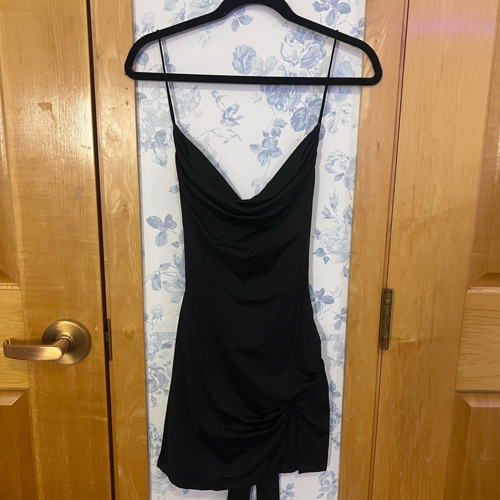 THATSSOFETCH black mini dress with a slit and an open back.